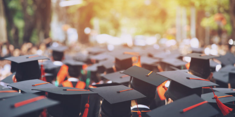 the tops of graduation caps of a crowd of graduating students