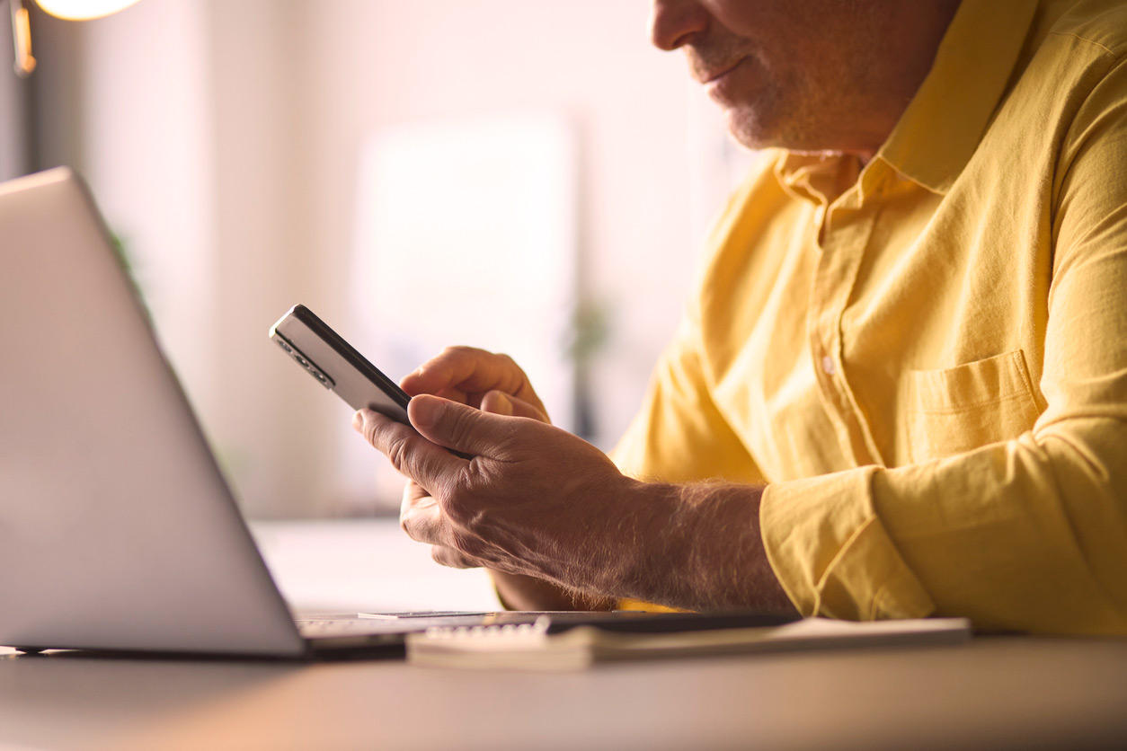 cropped shot of a man dialing on his mobile phone