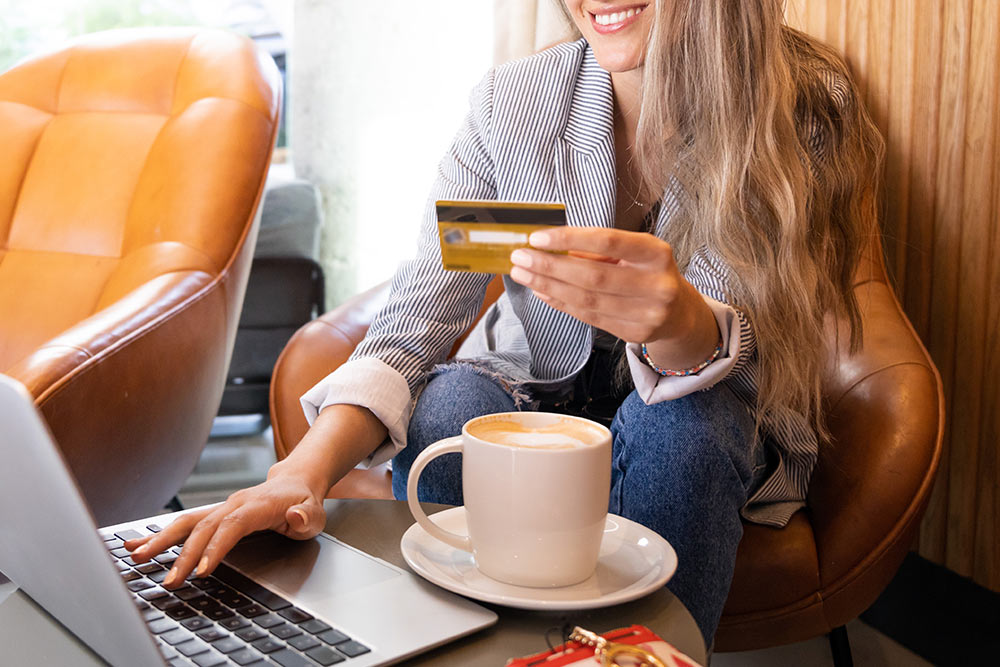 woman using credit card on laptop